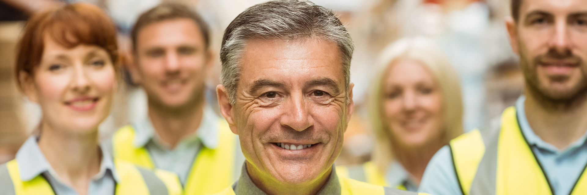 Close up of smiling group of associates wearing safety jackets